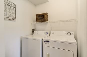 Two white front loading washing machines in a laundry room